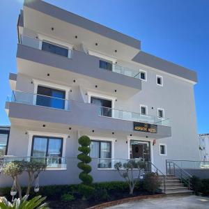 a white building with a sign on it at Hotel Adriatik Ksamil in Ksamil