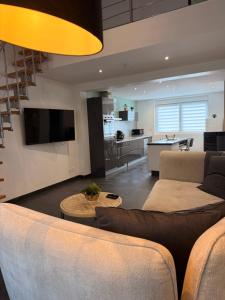 a living room with a couch and a kitchen at Duplex-Cocon-Proximité - frontières in Hombourg-Haut