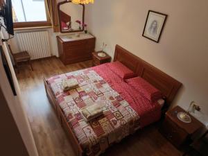 a bedroom with a bed with a red blanket and a mirror at Winter and Summer Cortina in Cortina dʼAmpezzo