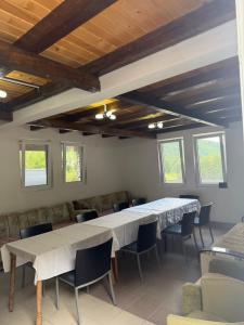 a dining room with two tables and chairs and windows at DreamHouse Grebaje in Gusinje