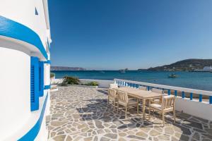 a table and chairs on a balcony overlooking the water at Pera Milos villa in Pollonia