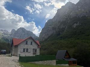 a house in the mountains with a car parked next to it at DreamHouse Grebaje in Gusinje