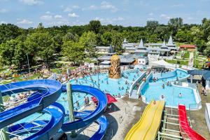 a large swimming pool with people in a water park at Wendell Apartman in Nyíregyháza