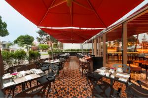 a restaurant with tables and chairs and a red umbrella at Hilton Lima Miraflores in Lima