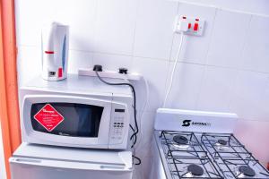 a microwave oven sitting on top of a refrigerator at Homes By Vee in Eldoret