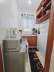 a kitchen with a microwave on top of a refrigerator at Homes By Vee in Eldoret +7 photos