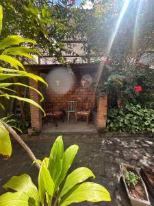 a patio with a table and chairs in a garden at Quartos Confortáveis em Belo Horizonte in Belo Horizonte