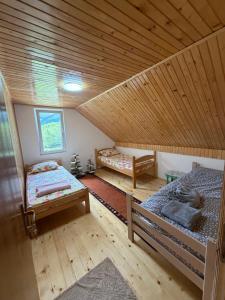 a room with two beds and a wooden ceiling at DreamHouse Grebaje in Gusinje +119 photos
