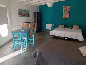 a room with a bed and a table and a bed at Cabañas don Julio in Maimará