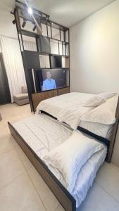 a bedroom with two beds and a tv on a wall at aura alraha village in Aqaba