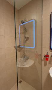 a bathroom with a shower with a sink and a mirror at aura alraha village in Aqaba +14 photos