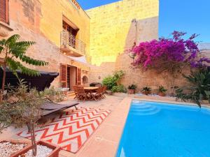 a courtyard with a swimming pool in a house at Charming 450-Year-Old House with Pool in Naxxar in Naxxar
