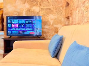 a couch with a television in a living room at Charming 450-Year-Old House with Pool in Naxxar in Naxxar