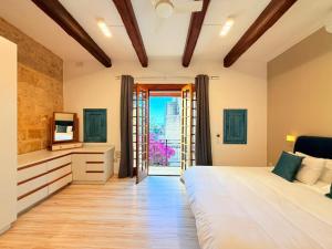 a bedroom with a large bed and a television at Charming 450-Year-Old House with Pool in Naxxar in Naxxar +35 photos