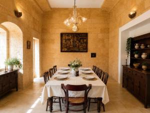 a dining room with a table with chairs and a chandelier at Charming 450-Year-Old House with Pool in Naxxar in Naxxar
