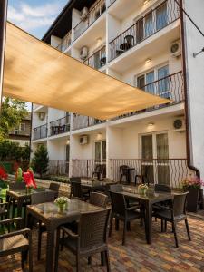 a patio with tables and chairs and a building at Sakura Hotel in Zatoka