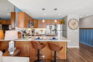 a kitchen with wooden cabinets and a large clock on the wall at Lahaina Roads 306 in Lahaina