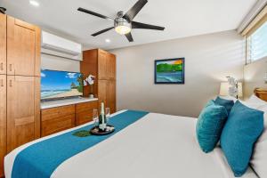 a bedroom with a bed and a ceiling fan at Lahaina Roads 306 in Lahaina +19 photos
