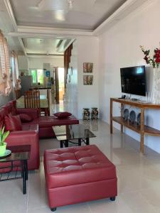 a living room with red couches and a tv at Nenita in Baybay