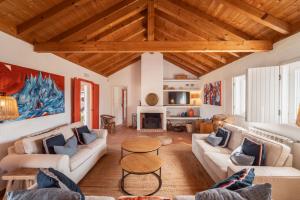 a living room with white furniture and wooden ceilings at Cerca do Sul in Brejao