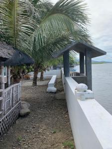 a white bear sitting on a wall next to the water at Nenita in Baybay