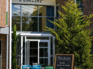 a sign in front of a building with a restaurant at Ibis Styles Evry Lisses Paris Sud in Courcouronnes