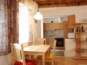 a kitchen with a wooden table and chairs in a room at Ferienhaus Schmidlhof in Oggau