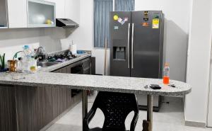 a kitchen with a stainless steel refrigerator and a counter at Apto Isabelu Girardot in Girardot