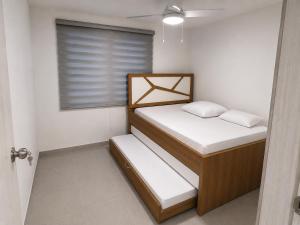 two beds in a small room with a window at Apto Isabelu Girardot in Girardot +6 photos
