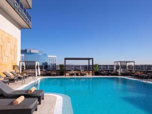 a swimming pool on top of a building at Pullman Dubai Creek City Centre in Dubai