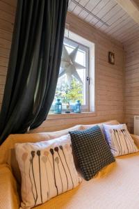 a bedroom with a bed with pillows and a window at Zlatar Zen Chalet in Vukovina