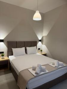 a bedroom with a large white bed with two pillows at Laki Hotel in Nea Plagia +90 photos