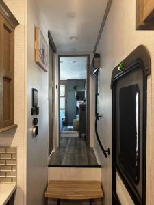 a hallway leading into a tiny house with a tv at EL Camper KW in Key West +4 photos