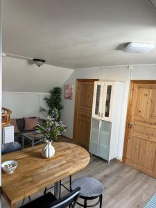 a living room with a wooden table and a kitchen at Loft apartment with 3 bedrooms in Trondheim +6 photos