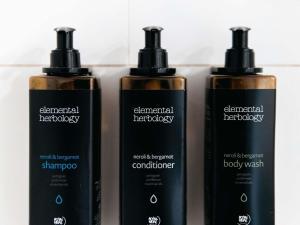 Eine Gruppe von drei Shampooflaschen, die nebeneinander stehen in der Unterkunft Mercure Sydney Parramatta in Sydney