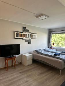 a bedroom with a bed and a flat screen tv at Loft apartment with 3 bedrooms in Trondheim