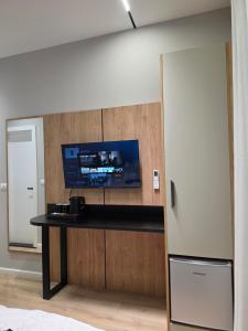 a kitchen with a counter with a tv on a wall at Vila Gabriel in Shkodër