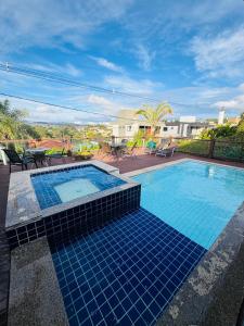 a swimming pool with blue tiles on the ground at Casa Brisa Escarpas in Capitólio
