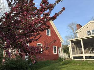 a red house with a tree with purple flowers at Hawks House Inn in Walpole +4 photos