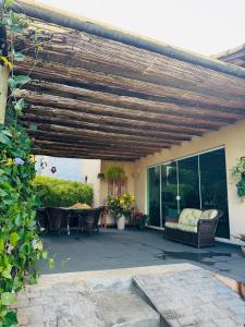 a patio with a wooden pergola with a table and chairs at Casa Brisa Escarpas in Capitólio