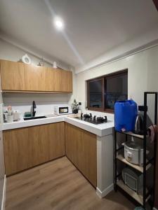 a kitchen with wooden cabinets and white counter tops at Casa Attika - Modern Glasshouse with Skyline Views in Antipolo +20 photos