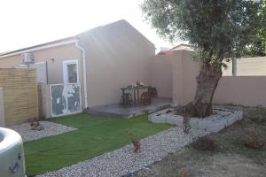 a small yard with a tree and a table at Curtido House Suits in Ílhavo