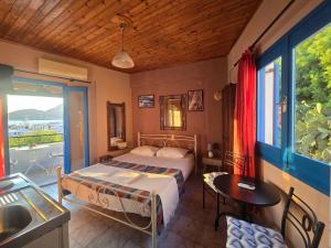 a bedroom with a bed and a table and a window at Agla Studio 2 in Fournoi