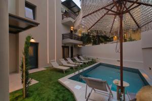 a pool in a building with chairs and an umbrella at Sea Salt Skiathos in Skiathos