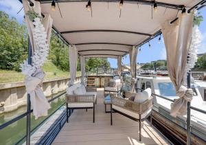 a deck on a boat with chairs and curtains at Love Room sur l'eau & Rooftop in Asnières-sur-Seine