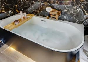 a white bath tub in a bathroom with a sink at Love Room sur l'eau & Rooftop in Asnières-sur-Seine +6 photos
