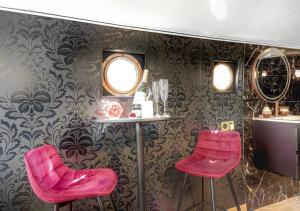 two pink bar stools in a room with wallpaper at Love Room sur l'eau & Rooftop in Asnières-sur-Seine