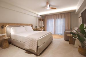 a bedroom with a white bed and a living room at Sea Salt Skiathos in Skiathos +94 photos