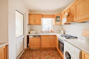 a kitchen with wooden cabinets and a stove top oven at Beautiful 3 Bedroom House in Ennistymon