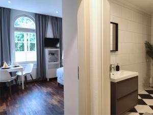 a bathroom with a sink and a room with a table at ApartZ - Celle - CityQuartier - bis 15 Personen - 4 Apartments in Celle +64 photos